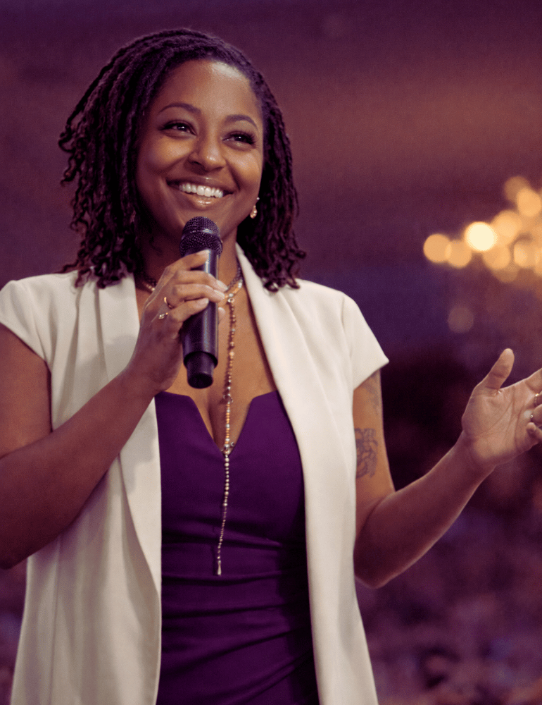 Woman speaking into a microphone with a blurred background