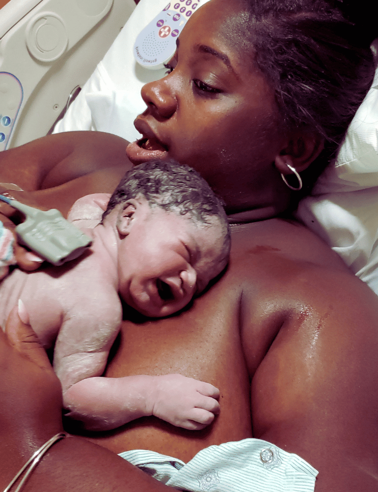 Newborn baby being held by a woman in a hospital setting