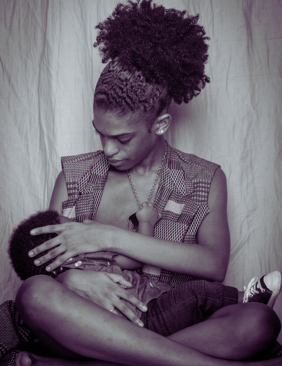 Woman nursing a child against a plain background