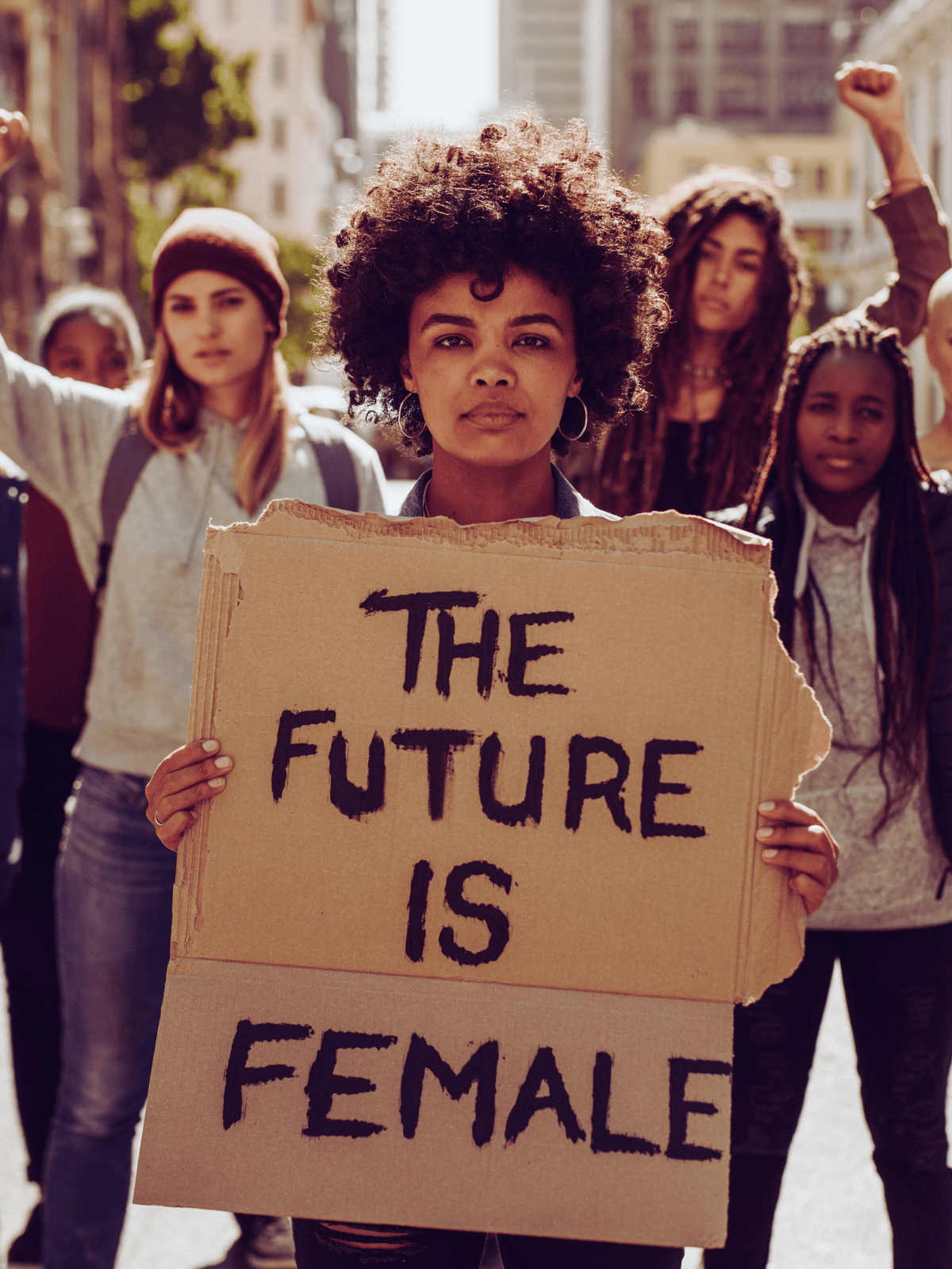 Woman holding a sign that reads 'The Future is Female' in a protest setting.